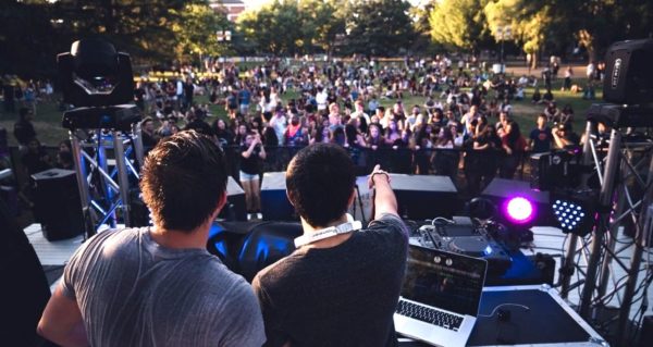 two guys in a dj booth at a small festival