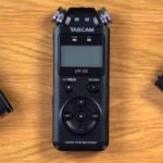 Three external recording devices lay next to each other on a well-lit wooden surface. On the left is an Evermixbox5, in the middle is a Tascam DR-05, and on the right is a Howler box.