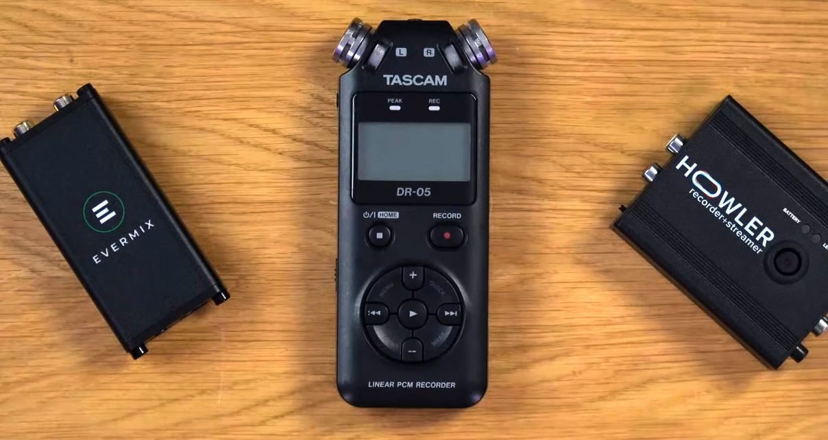 Three external recording devices lay next to each other on a well-lit wooden surface. On the left is an Evermixbox5, in the middle is a Tascam DR-05, and on the right is a Howler box.