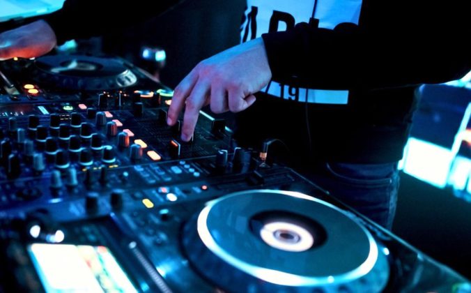 A DJ mixing in a nightclub on pro DJ gear.