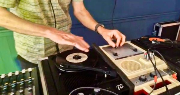 A DJ spinning seven inch singles on a custom a set-up.