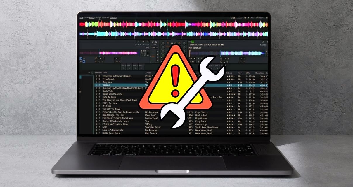 A laptop displaying Mixxx DJ software against a concrete background. There's a yellow, orange, and red warning sign indicating a troubleshooting issue.