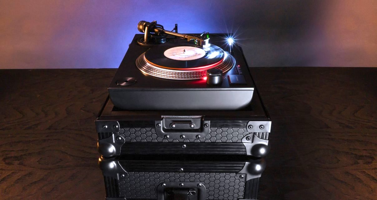 Side view of a Reloop RP-7 turntable sitting on a sturdy black case.