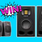 Two pairs of Adam Audio speakers and a pair of headphones on a light blue background. There is a comic book-style white, black, and hot pink graphic that says "Win!".