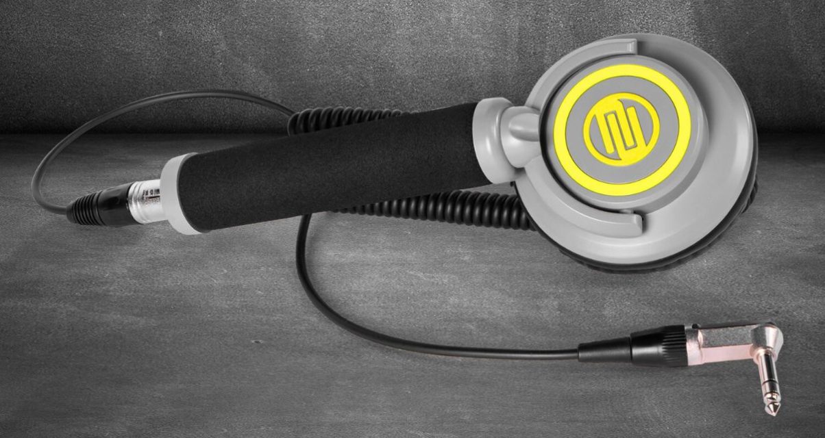 A single Reloop RHP-10 Mono Neon headphone laying flat against a concrete background. The headphones have black, light grey, and bright yellow colouring.