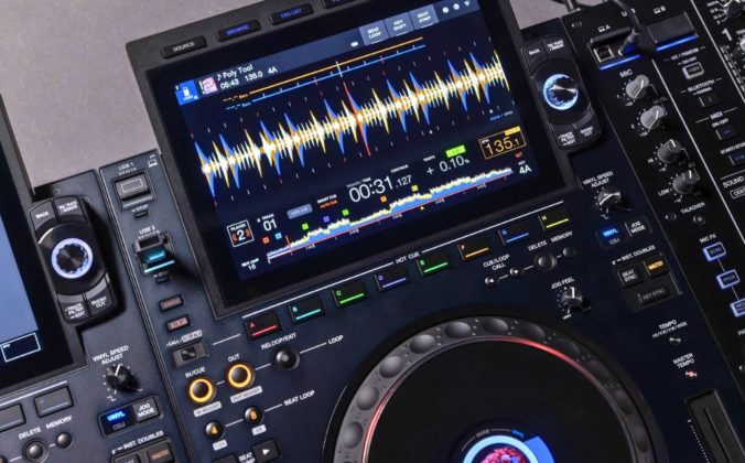 Close-up of an AlphaTheta CDJ-3000x media player featuring dual screens displaying waveforms, track info, and various control buttons for mixing.