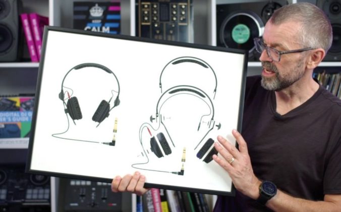 DJ tutor Phil Morse holds a framed illustration of Sennheiser HD-25 headphones with detailed schematic drawings against a white background. Behind him is a large white bookshelf containing various DJ gear, books, and trinkets.
