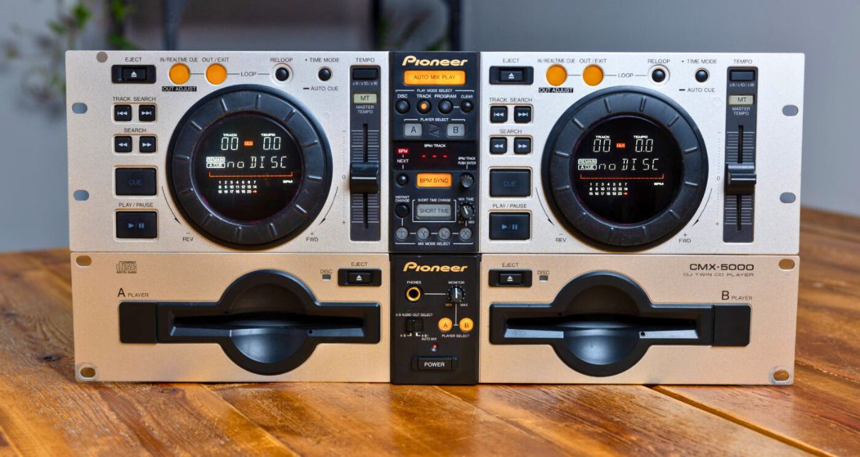 A silver Pioneer CMX-5000 twin CD deck sitting in a well-lit room on a wooden table.