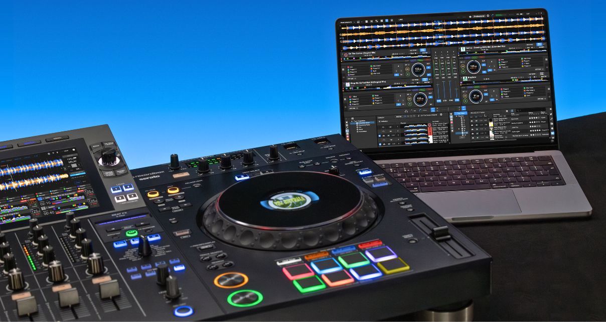 An XDJ-AZ and silver laptop displaying Rekordbox DJ software sit side by side on a table in front of a blue wall.