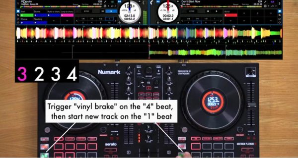 Overhead shot of a person mixing on a DJ controller on a light wooden desk. At the top of the screen, there's a cutout of DJ software, showing track BPMs and waveforms. The annotated text onscreen reads "Trigger "vinyl brake" on the "4" beat, then start new track on the "1" beat.