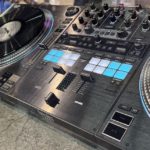 Hercules Unveils DJControl T10 With 10" Motorised Jogwheels Angled top-down shot of a Hercules T10 controller. The design is mostly black and grey with white and blue on the performance pads.