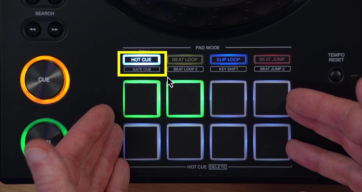 A person's hands gesturing toward the performance pads on an XDJ-AZ, with the Hot Cue and Gate Cue pad mode buttons highlighted above the eight performance pads, showing how to switch between the two modes.