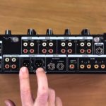 DJ Mixer Inputs & Outputs: Every Connection Explained A person points at the Master outputs on a Pioneer DJ DJM-A9 mixer. The mixer is stood upright on a wooden desk in a well-lit room.