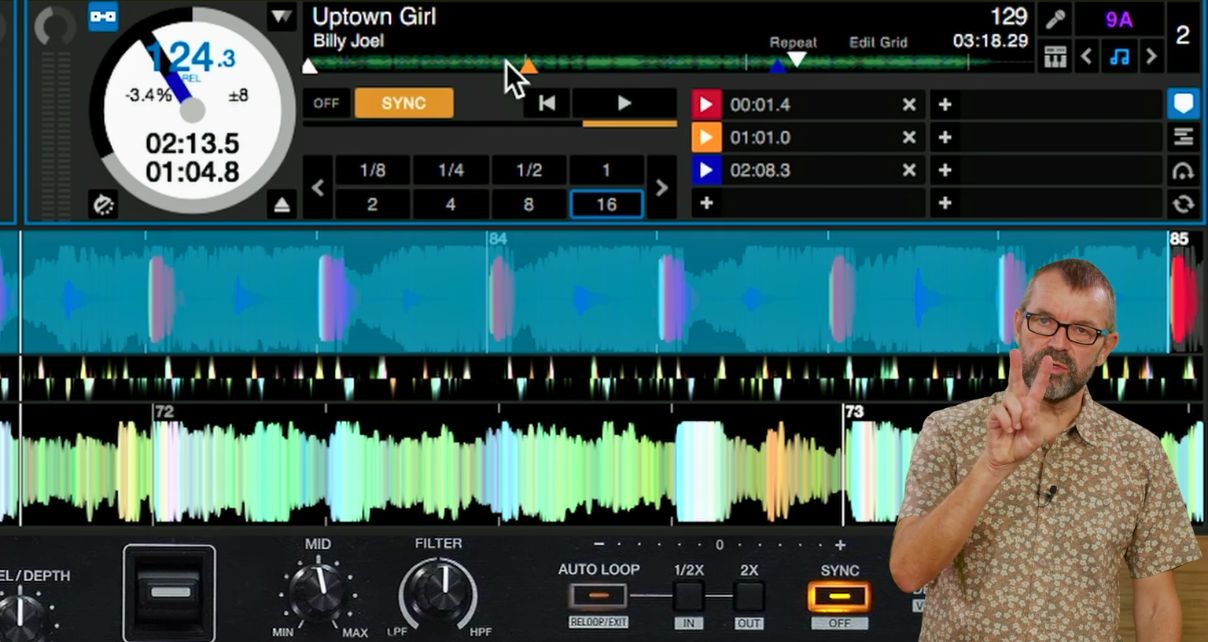 Phil Morse holds up two fingers against a DJ software screen showing Billy Joel's "Uptown Girl" loaded on a deck with a loop active.