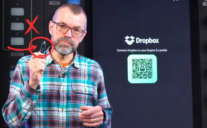 Phil Morse holds up a USB drive with a red X and circle arrow graphic overlaid, standing in front of a Rane System One DJ unit and a screen showing the Dropbox Engine DJ profile connection page with a QR code.