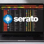 Lexicon 1.10 Brings Serato 4.0 Support, Track Timeline & Play History Lexicon DJ library management software on a MacBook laptop with the Serato logo overlaid, highlighting the new Serato 4.0 database support in version 1.10. The laptop is sitting against the wall in a grey, concrete-like room.
