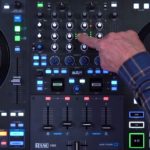 A close-up of a Rane System One DJ controller showing the mixer section, with a hand pointing to the channel meters near the top.