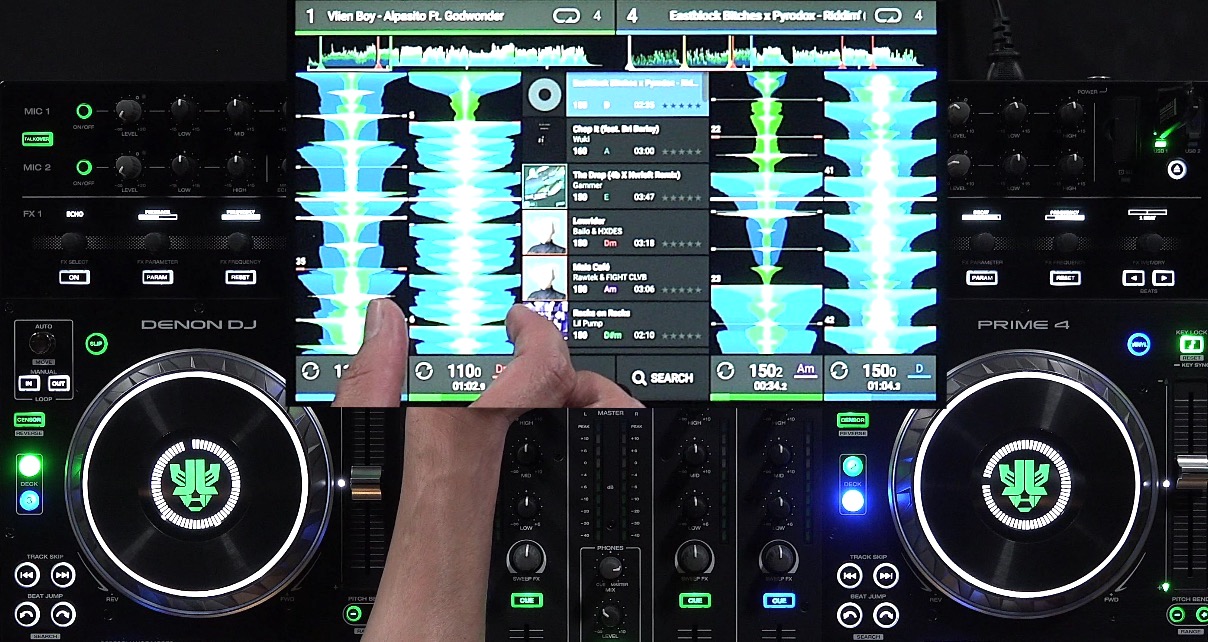 A close-up of a Denon DJ Prime 4 touchscreen showing two tracks loaded with their waveforms visible. A person's thumb and index finger sit on either side of the waveform to indicate thickness.